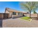 Back of the home with xeriscaped backyard, grass and tree at 13536 W Peck Dr, Litchfield Park, AZ 85340