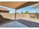 This backyard is xeriscaped with a covered patio, concrete slab, stone and block fencing at 13536 W Peck Dr, Litchfield Park, AZ 85340