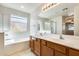 Bright bathroom featuring double vanity, bathtub, and natural light at 13536 W Peck Dr, Litchfield Park, AZ 85340