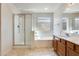 Bright bathroom features a shower and a separate bathtub with a window for natural lighting at 13536 W Peck Dr, Litchfield Park, AZ 85340