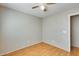 Cozy bedroom showcases wood-look floors, soft neutral wall, ceiling fan and ample natural light at 13536 W Peck Dr, Litchfield Park, AZ 85340