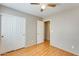 This bedroom features hardwood floors, neutral walls, ceiling fan, and closet with louvered doors at 13536 W Peck Dr, Litchfield Park, AZ 85340