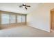 Neutral living room with carpet, ceiling fan, and ample natural light from windows at 13536 W Peck Dr, Litchfield Park, AZ 85340