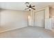 Spacious carpeted living room with a ceiling fan and neutral wall paint at 13536 W Peck Dr, Litchfield Park, AZ 85340