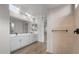 Bright bathroom featuring double vanities, large mirrors, and a glass-enclosed shower with sleek, modern design at 13757 W Forest Pleasant Pl, Peoria, AZ 85383