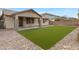 Exterior shot of backyard features artificial turf, gravel, and covered patio at 19862 E Carriage Way, Queen Creek, AZ 85142