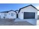 New single-Gathering home with a black garage door and desert landscaping under a clear sky at 2133 N Valley Dr, Apache Junction, AZ 85120