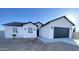 Newly constructed single-Gathering home with black garage door and desert surroundings at 2133 N Valley Dr, Apache Junction, AZ 85120