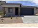 Charming single-story home featuring a two-car garage, desert landscaping, and a covered entryway at 23335 W Monona Ln, Surprise, AZ 85387
