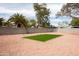 Spacious backyard with low-maintenance gravel, palms, and a small lawn at 252 S Cholla St, Gilbert, AZ 85233