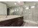 This updated bathroom has a double vanity, a walk-in shower with dual shower heads, and modern fixtures at 3551 E Louise Dr, Phoenix, AZ 85050