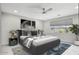 Bedroom with a ceiling fan, neutral gray decor, a patterned area rug, and a window overlooking the backyard at 3551 E Louise Dr, Phoenix, AZ 85050