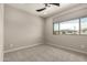 This bedroom features plush carpet, a modern ceiling fan, and a large window with a view at 3551 E Louise Dr, Phoenix, AZ 85050