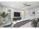 Comfortable bedroom featuring a large TV, ceiling fan, and doorway to a walk-in shower at 3551 E Louise Dr, Phoenix, AZ 85050