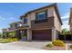 Modern two-story home with a brown garage door, brick facade, and desert landscaping at 3551 E Louise Dr, Phoenix, AZ 85050