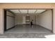 Spacious garage with epoxy flooring, a full wall of custom cabinets, and an overhead storage rack at 3551 E Louise Dr, Phoenix, AZ 85050