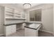 Bright home office has wood tile floors, built-in shelving, a modern light fixture, and a U-shaped desk at 3551 E Louise Dr, Phoenix, AZ 85050