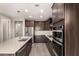 Modern kitchen featuring stainless steel appliances, large island, dark cabinets, and tile flooring at 3551 E Louise Dr, Phoenix, AZ 85050