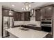 Bright kitchen featuring stainless steel appliances, dark cabinets, large island, and pendant lighting at 3551 E Louise Dr, Phoenix, AZ 85050