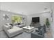 Bright living room featuring a large sofa, contemporary decor, and sliding glass doors to the backyard at 3551 E Louise Dr, Phoenix, AZ 85050