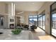 Open living space with marble fireplace, wet bar, wood floors, modern lighting, and sliding glass doors to balcony at 39332 N Old Stage Rd, Cave Creek, AZ 85331