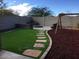 Backyard features a synthetic lawn, fire pit, playground, and privacy wall at 42920 N Raleigh Ct, Anthem, AZ 85086