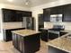 Modern kitchen with stainless steel appliances, granite countertops, kitchen island and espresso cabinets at 42920 N Raleigh Ct, Anthem, AZ 85086