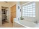 Soaking tub featuring a glass block window and built-in storage at 486 E Devon Dr, Gilbert, AZ 85296