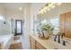 Bathroom featuring a double sink vanity, glass shower, soaking tub, and good lighting at 486 E Devon Dr, Gilbert, AZ 85296