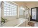 Bright bathroom featuring a soaking tub, glass shower, and a glass block window at 486 E Devon Dr, Gilbert, AZ 85296