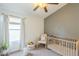 Bedroom with a neutral color scheme, crib, rocking chair, and a ceiling fan at 486 E Devon Dr, Gilbert, AZ 85296