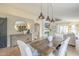 Elegant dining area with a rustic wooden table, comfortable chairs, and modern pendant lighting at 486 E Devon Dr, Gilbert, AZ 85296