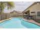 Private backyard pool with lounge chairs, covered patio, and secure fencing, perfect for outdoor relaxation and entertainment at 486 E Devon Dr, Gilbert, AZ 85296