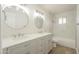 This bathroom features a double sink vanity, wood-look tile, and a shower at 562 N 104Th St, Mesa, AZ 85207