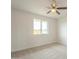 This bedroom includes neutral carpet, a ceiling fan, and a window overlooking the front yard at 562 N 104Th St, Mesa, AZ 85207