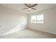 This bedroom includes neutral carpet, a ceiling fan, and a window overlooking the street at 562 N 104Th St, Mesa, AZ 85207