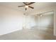 This bedroom includes neutral carpet, a ceiling fan, and a sliding door mirrored closet at 562 N 104Th St, Mesa, AZ 85207