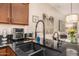 Close up of kitchen sink with black granite countertop and stainless steel appliances at 6202 E Mckellips Rd # 46, Mesa, AZ 85215