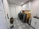 Well-lit laundry room with black and white patterned tile, wooden counter, and updated washer and dryer at 6429 E Jean Dr, Scottsdale, AZ 85254