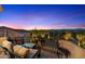 Inviting outdoor seating on a wrought iron balcony showcases desert views under a colorful evening sky at 10471 E White Feather Ln, Scottsdale, AZ 85262