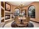 Elegant dining room with round table, chandelier, fireplace and picture frame windows at 10471 E White Feather Ln, Scottsdale, AZ 85262