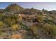 Elegant estate nestled amidst natural rock formations featuring desert landscaping, and a circular driveway at 10471 E White Feather Ln, Scottsdale, AZ 85262