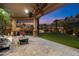 Outdoor patio area with palm trees and lush landscaping at twilight at 10471 E White Feather Ln, Scottsdale, AZ 85262