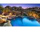 Backyard pool area with waterfall feature and statue surrounded by desert landscaping at 10471 E White Feather Ln, Scottsdale, AZ 85262