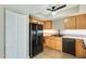 Bright kitchen features wooden cabinets, black appliances, and plenty of storage space at 1051 S Dobson Rd # 117, Mesa, AZ 85202