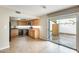 Modern kitchen with wood cabinets, black appliances, and sliding glass door to the outdoors with fan at 1051 S Dobson Rd # 117, Mesa, AZ 85202