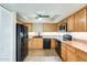 Well-lit kitchen featuring modern black appliances and ample wood cabinetry for storage and meal prep at 1051 S Dobson Rd # 117, Mesa, AZ 85202