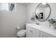 Bathroom featuring a new vanity, round mirror, toilet, and a shower window providing natural light at 1531 W Colter St # 7, Phoenix, AZ 85015