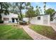 Inviting exterior view of the townhomes, featuring lush green lawn, brick pathway, and mature trees at 1531 W Colter St # 7, Phoenix, AZ 85015