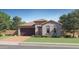 Charming single-story home with a tile roof, brick driveway, and a well-manicured lawn at 15806 W Kendall St, Goodyear, AZ 85338